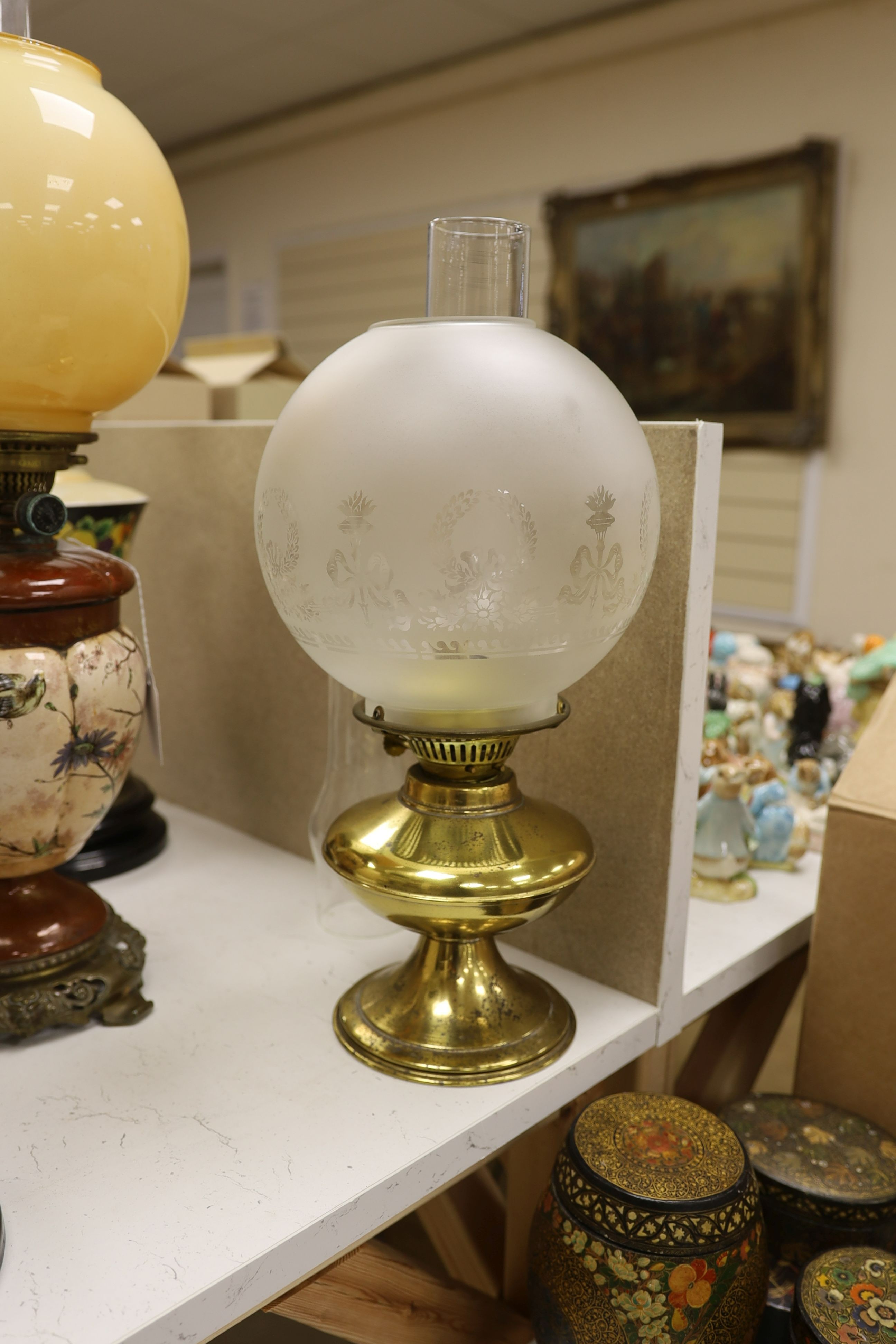 A Doulton style pottery oil lamp and four other glass and brass oil lamps, tallest 54 cms including glass shade.